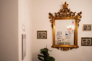 a mirror hanging on a wall with pictures on it at Briogna by Maravigghia Palermo in Palermo