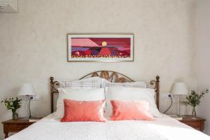 een slaapkamer met een bed met witte lakens en roze kussens bij Mas Montbrio Belvedere in Cambrils