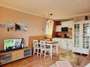 eine Küche und ein Wohnzimmer mit einem Tisch und Stühlen in der Unterkunft Appartmenthaus Ostseestrand in Kühlungsborn