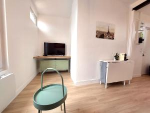 a living room with a chair and a television at Superbe 2 pièces rénové et calme in Aubervilliers