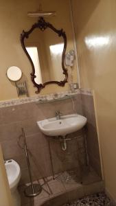 a bathroom with a sink and a mirror and a toilet at Relais Corso Storico in Pisa