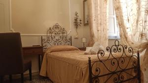 a bedroom with a bed and a desk and a window at Relais Corso Storico in Pisa