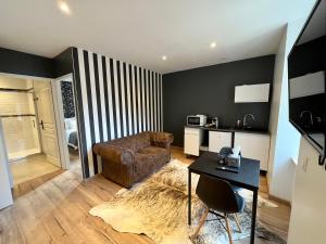 a living room with a couch and a table at LesCinqSuites / Le Chivas - DABNB in Limoges