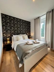- une chambre dotée d'un grand lit avec un mur aux accents noirs dans l'établissement LesCinqSuites / Le Chivas - DABNB, à Limoges