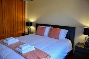 1 dormitorio con 1 cama con toallas en Tranquility Apartment, en Caniço