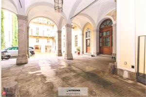 een lege binnenplaats van een gebouw met zuilen bij Atriums Apartment Giambattista Bogino in Turijn