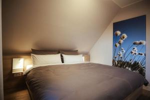 um quarto com uma cama grande e uma pintura na parede em Schicke Bude em Soltau