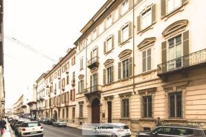 een straat met auto's geparkeerd voor een gebouw bij Atriums Apartment Giambattista Bogino in Turijn
