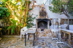 a stone fireplace with a table and chairs in a garden at Villa Mar in Teià