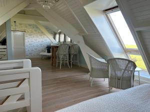 une chambre avec un escalier, des chaises et une table dans l'établissement Villa Nieuwland B&B, à Den Oever