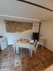 a table and chairs in a room with a stone wall at Col di Lana in Rocca di Botte
