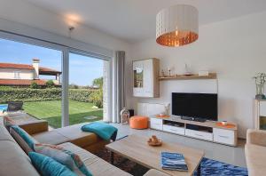 a living room with a couch and a tv at Villa Sky Dream in Bužinija