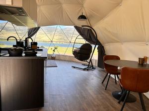 Cette tente avec vue comprend une table et des chaises. dans l'établissement Glamping Dome - Pinot, à Cromwell