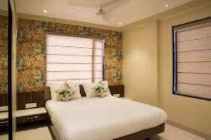 a bedroom with a white bed with a window at Hotel Sangat Regency in Bhopal