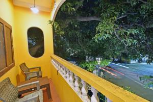 Un balcón con sillas y una ventana con una calle. en Coral Home Stay, en Pondicherry