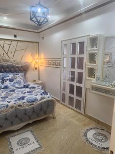 a bedroom with a bed with a blue and white comforter at Luxueux platinium in Libreville