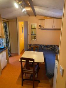 a kitchen and living room with a table and a couch at Mobil-Home standard in Voyennes