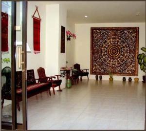 a living room with a large rug on the wall at Penzy Guest House in Chaweng
