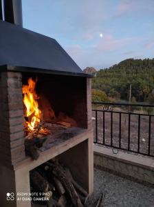 a fireplace on a balcony with a view of the mountains at Casa Rural Puente Del Segura in Elche de la Sierra