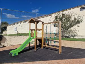 un parque infantil con un tobogán verde y una pista de patinaje en Bungalows Playa de Oyambre en San Vicente de la Barquera