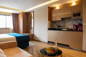 a hotel room with a bed and a bowl of fruit on a table at First Suites Hôtel in Rabat