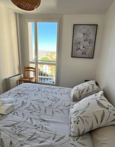 Un dormitorio con una cama grande y una ventana en Spacieux T2 idéalement placé, en Toulouse