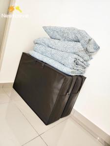 a pile of towels sitting on top of a black bag at Mutiara Bali Residence Suites By Nestcove in Melaka