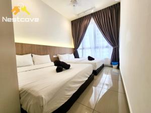 a hotel room with two beds and a window at Mutiara Bali Residence Suites By Nestcove in Melaka