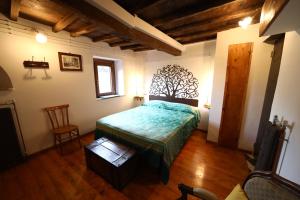 a bedroom with a bed with a tree mural on the wall at Col di Lana in Rocca di Botte
