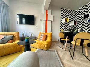een woonkamer met geel meubilair en een tafel bij Ermou funky lofts in Athene
