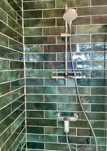 a shower with a hose attached to a brick wall at La Cabane 56 - calme - cosy - chaleureuse - sans vis-à-vis in Lège-Cap-Ferret +11 photos