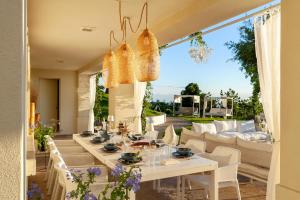 a dining room with a white table and chairs at Villa Belvedere in Bertinoro