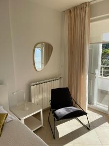 a bedroom with a chair and a table and a mirror at Villa Katarina Dubrovnik in Dubrovnik