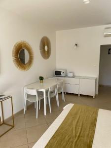 Jest to biały pokój ze stołem, krzesłami i kuchenką mikrofalową. w obiekcie Villa Katarina Dubrovnik w Dubrowniku