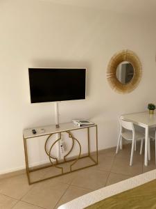 a living room with a table and a television on a wall at Villa Katarina Dubrovnik in Dubrovnik