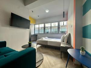 een slaapkamer met een bed, een bank en een tv bij Ermou funky lofts in Athene