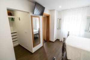 Schlafzimmer mit einem Bett, einem Fenster und einem Spiegel in der Unterkunft Madeira Bird House - House in the Mountains With Garden in São Vicente + 43 Fotos