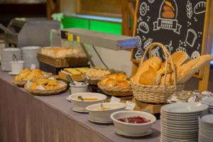 a buffet line with bread and baskets of food at Felix River Kwai Resort - SHA Plus,Certified in Kanchanaburi City
