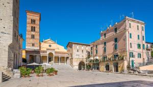 a city street with buildings and a clock tower at Luxury Suite - Teatro Romano - Duomo - Centro Storico Wi-Fi in Terracina