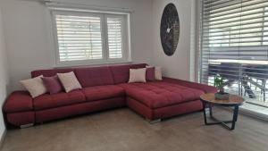 un sofá rojo en una sala de estar con mesa en Apartmaji PR' KERIN en Laško