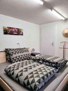a bedroom with a black and white comforter on a bed at Lakeview Basement Apartment near Interlaken in Niederried