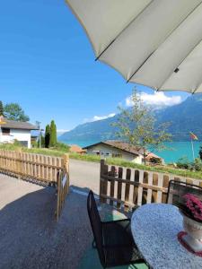 a table and chairs and an umbrella on a patio at Lakeview Basement Apartment near Interlaken in Niederried