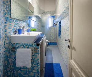 baño con lavabo y suelo de baldosa azul en Red House Ostiense Historic building, en Roma