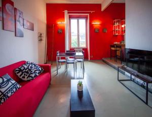 sala de estar con paredes rojas y sofá rojo en Red House Ostiense Historic building, en Roma
