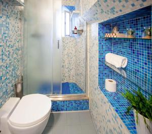 y baño de azulejos azules con aseo y ducha. en Red House Ostiense Historic building, en Roma