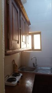 una pequeña cocina con fregadero y ventana en Vue sur l'Atlantique, en Cotonou