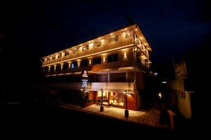 um edifício com luzes em cima à noite em ARIAT AVENUE em Wayanad