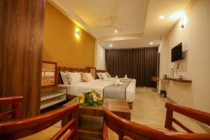 a hotel room with a bed and a television at ARIAT AVENUE in Wayanad