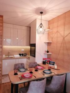 a kitchen with a table with chairs and a dining room at Apartman 21 Vila Elsa III Zlatibor in Zlatibor