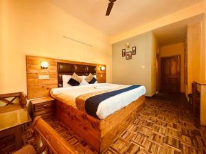um quarto com uma grande cama de madeira num quarto em Hotel Kalinga Grand - Top Rated Most Awarded Property In Manali em Manali